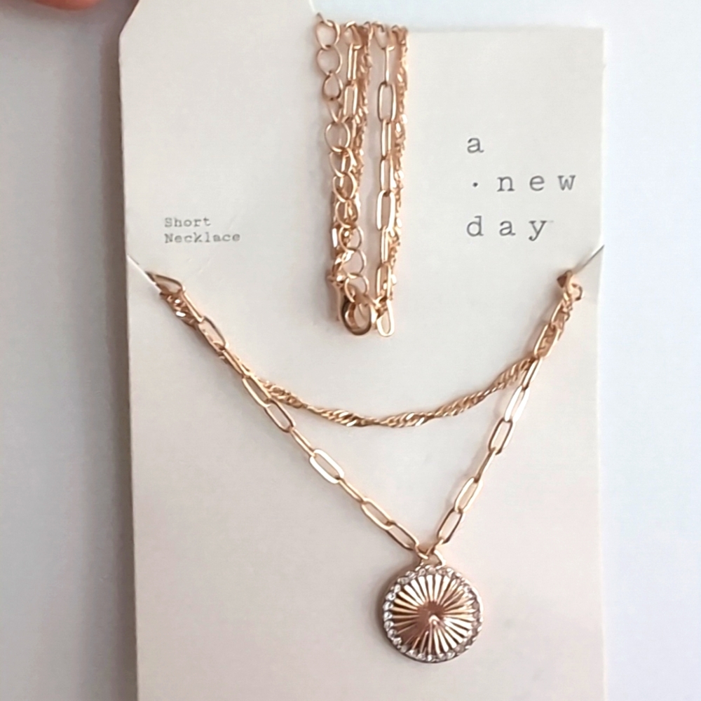 A . New day gold double chain neclace with sun medallion. NWT